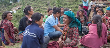 staff member talking to a group of beneficiaries