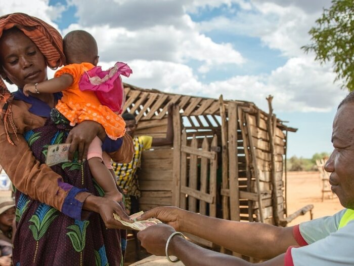  Kvinna som håller sitt barn och tar emot kontanthjälp