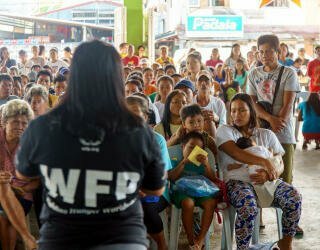 WFP-personal förklarar registreringsprocessen för medlemmarna i Irosin-samhället som deltar i det prognosbaserade finansieringsprojektet. Foto: WFP Philippines/Arete Philippines/Arete 