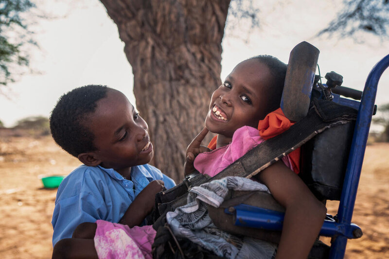 Boy with his sister who lives with a disability in Kenya