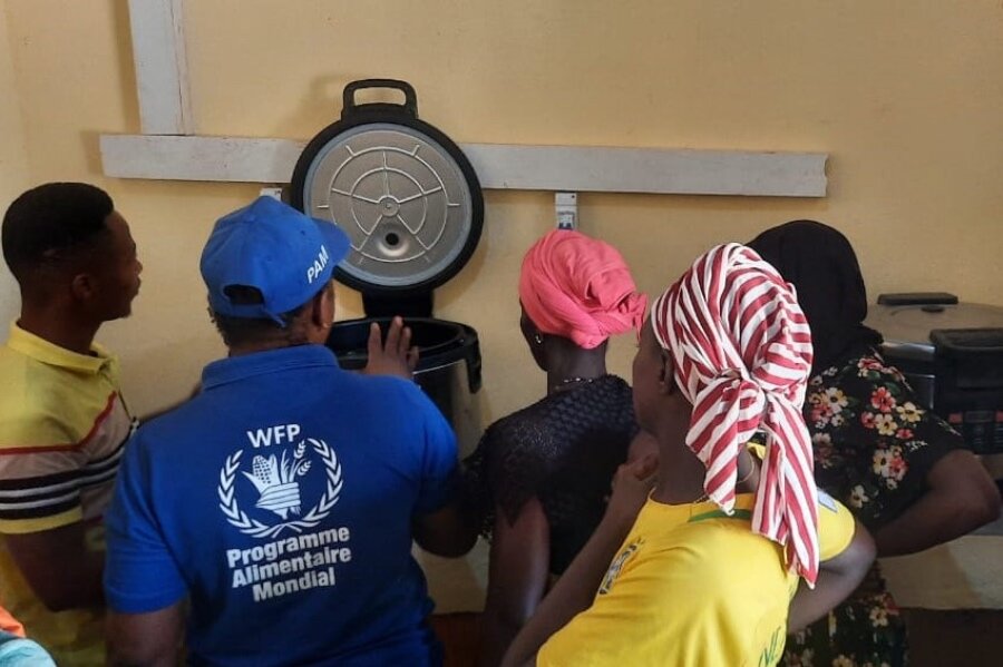 A WFP employee shows women in southern Guinea how to use solar-powered cookers to make WFP school meals. Photo: WFP/Youssouf Kaba 