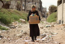 Girl holding a WFP box filled with items. 